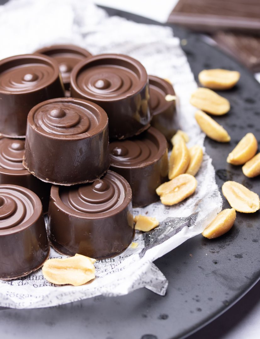 Premium Photo  Top view of squeezing filling of salted caramel cream from  confectionery bag into candy molds for preparing handmade chocolate pralines